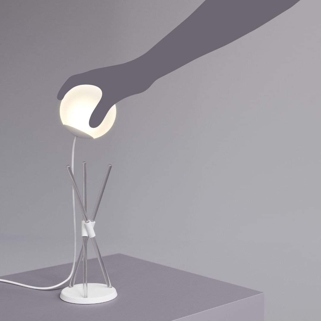 Somni Lamp featuring a removable spherical shade resting on a sleek stand with acrylic rods and a concrete base. The lamp emits a warm ambient glow and can be placed on various surfaces, including tabletops and laps, offering versatile lighting. Lamp by Tovaform